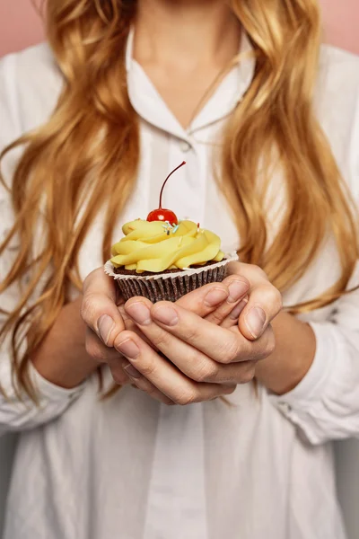 Attraktives Mädchen im weißen Hemd hält Cupcakes in der Hand — Stockfoto