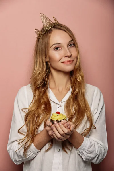 Menina atraente com uma coroa e cupcake — Fotografia de Stock