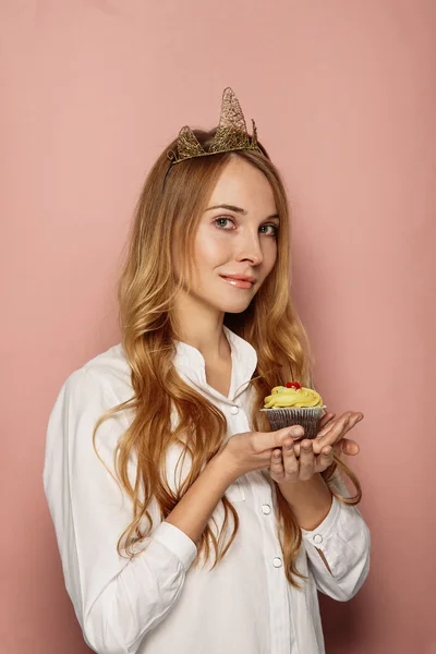 Menina atraente com uma coroa e cupcake — Fotografia de Stock