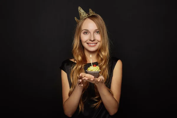 Aantrekkelijk meisje met een kroon en cupcake — Stockfoto