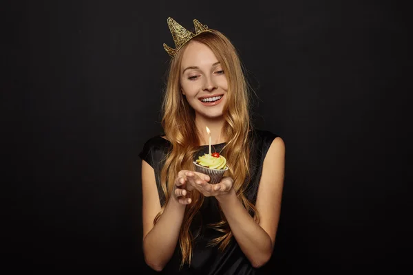 Attraktiva flicka med en krona och cupcake — Stockfoto