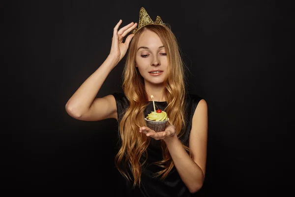Aantrekkelijk meisje met een kroon en cupcake — Stockfoto