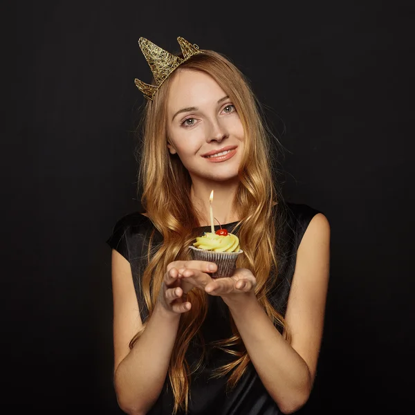 Aantrekkelijk meisje met een kroon en cupcake — Stockfoto