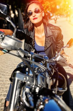 Motorcu kız bir motosiklet üzerinde bir deri ceketli