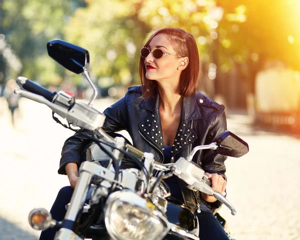Menina motociclista em uma jaqueta de couro em uma motocicleta — Fotografia de Stock