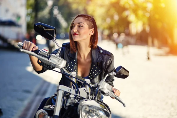 Chica motorista en una chaqueta de cuero en una motocicleta —  Fotos de Stock