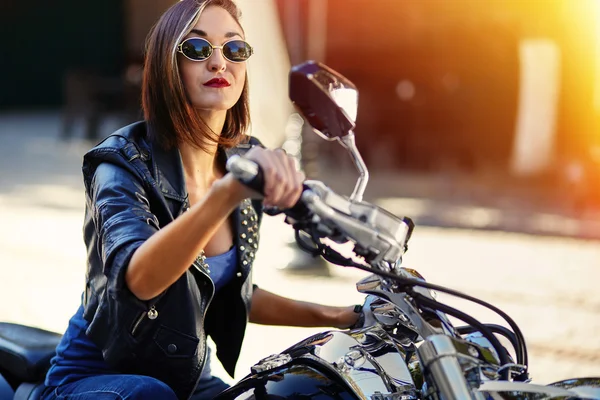 Biker meisje in een lederen jas op een motorfiets — Stockfoto