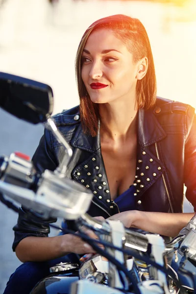 Chica motorista en una chaqueta de cuero en una motocicleta — Foto de Stock