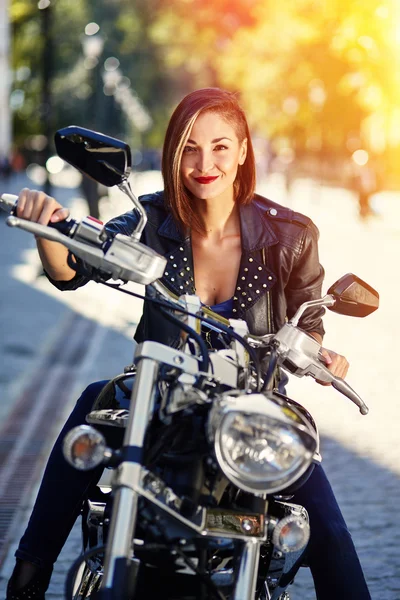Biker meisje in een lederen jas op een motorfiets — Stockfoto