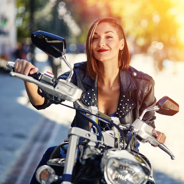 Chica motorista en una chaqueta de cuero en una motocicleta — Foto de Stock