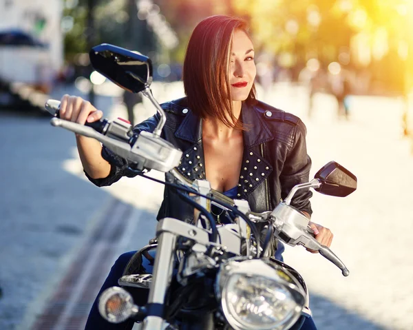 Biker meisje in een lederen jas op een motorfiets — Stockfoto