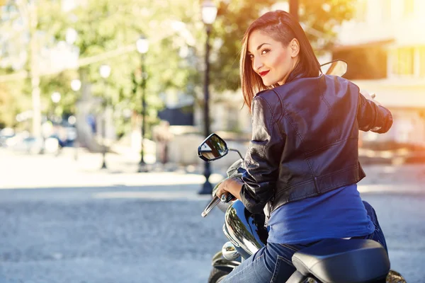 Biker meisje in een lederen jas op een motorfiets — Stockfoto