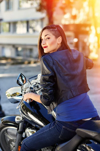 Chica motorista en una chaqueta de cuero en una motocicleta — Foto de Stock