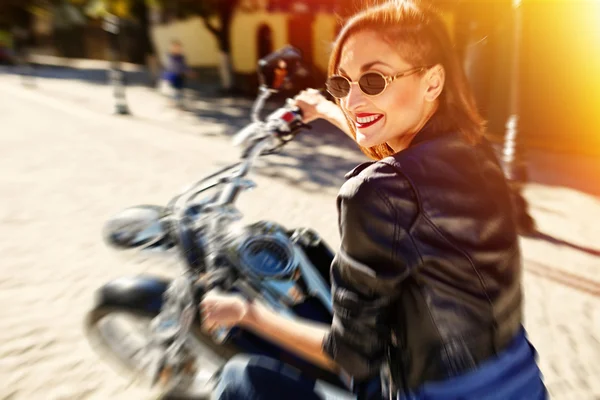 Menina motociclista em uma jaqueta de couro montando uma motocicleta — Fotografia de Stock