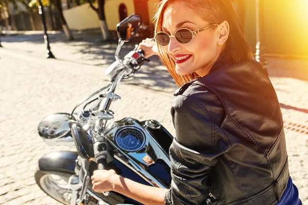 Biker girl in a leather jacket riding a motorcycle — Stock Photo, Image