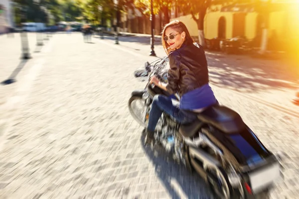Biker meisje in een lederen jas rijden op een motorfiets — Stockfoto