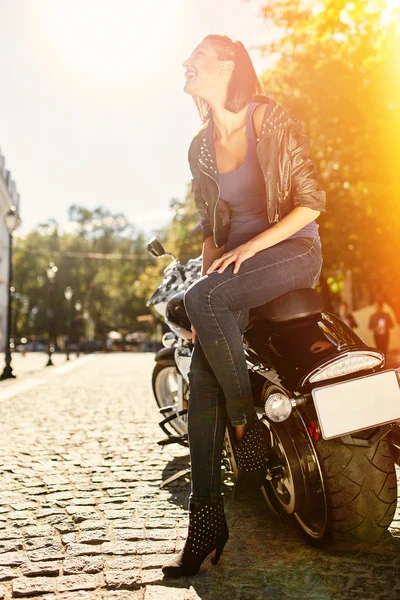 Chica motorista en una chaqueta de cuero en una motocicleta — Foto de Stock