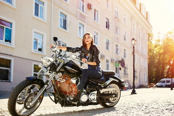 Biker meisje in een lederen jas rijden op een motorfiets Rechtenvrije Stockfoto's