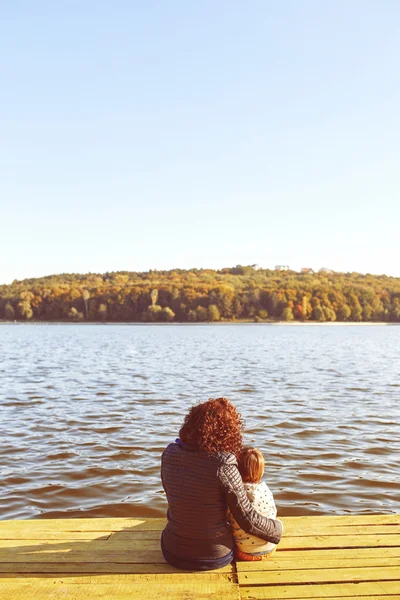 Мама і син, відпочиваючи на березі озера — стокове фото