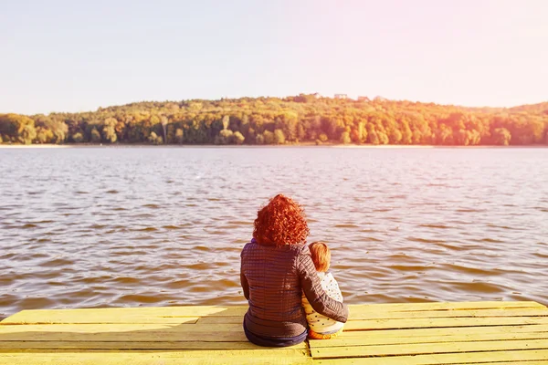 Mãe e filho descansando junto ao lago — Fotografia de Stock