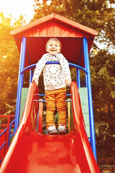 Niño jugando en toboganes infantiles — Foto de Stock