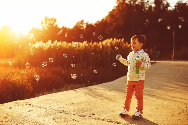Niño jugando con burbujas de jabón — Foto de Stock