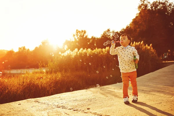 Niño jugando con burbujas de jabón — Foto de Stock