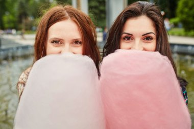 İki kız kardeş parkta pamuk şeker yemek