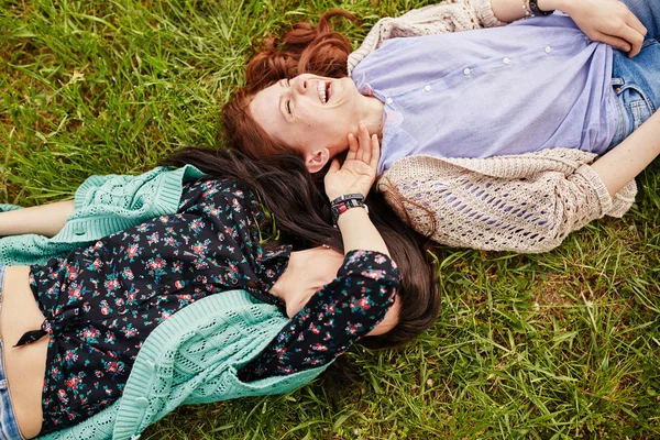 Duas irmãs alegres deitadas na grama — Fotografia de Stock