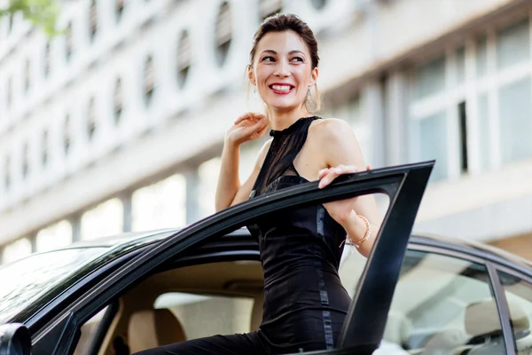 Muchacha atractiva de pie cerca del coche — Foto de Stock