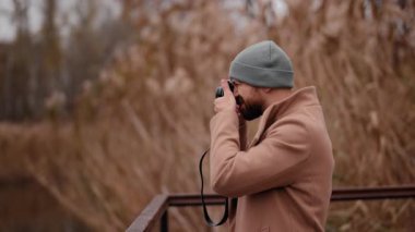Bereli ve ceketli sakallı bir adam bir sonbahar sahnesi, doğa hobisinin keyfini çıkarıyor..