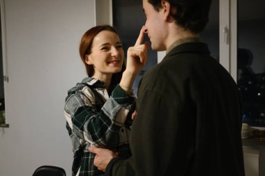 Neşeli bir kadın, evdeki neşeli, samimi bir anda bir erkeğin burnunu tıklatır..