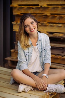 Çekici kız bir palet üzerinde oturan