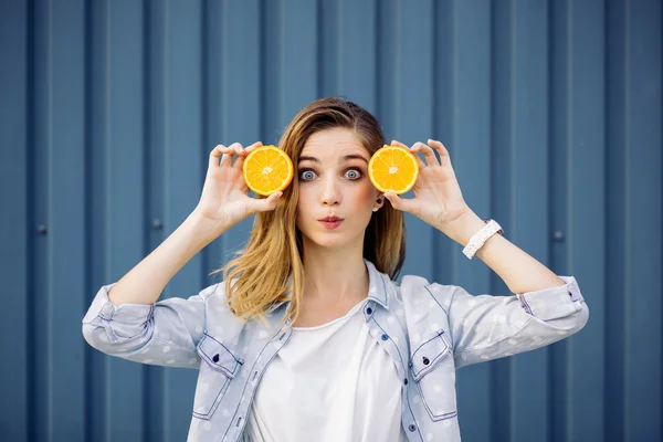 Lachende vrouw met twee oranje in handen — Stockfoto