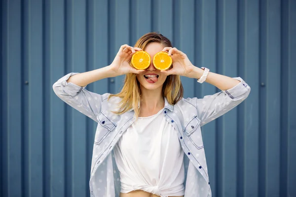 Mujer sonriente sosteniendo dos naranjas en las manos — Foto de Stock
