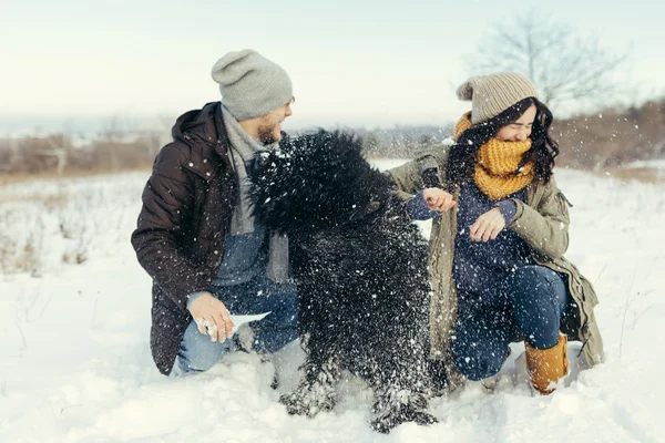 Jeune couple marchant avec un chien dans une journée d'hiver — Photo