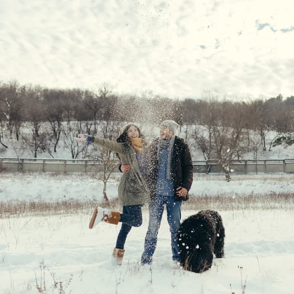 Casal jovem andando com um cão em um dia de inverno — Fotografia de Stock