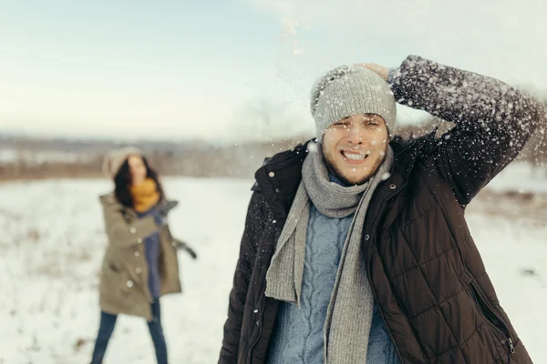 Glada unga paret spelar snöbollar — Stockfoto