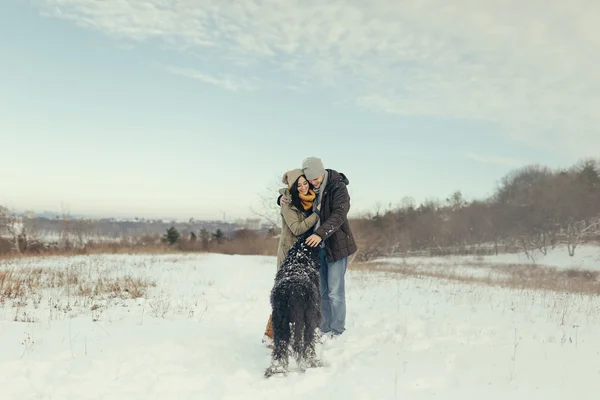 Junges Paar geht an einem Wintertag mit Hund spazieren — Stockfoto