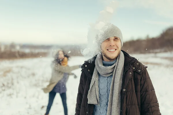 Веселая молодая пара играет в снежки — стоковое фото