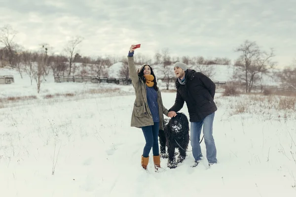 Junges Paar geht an einem Wintertag mit Hund spazieren — Stockfoto