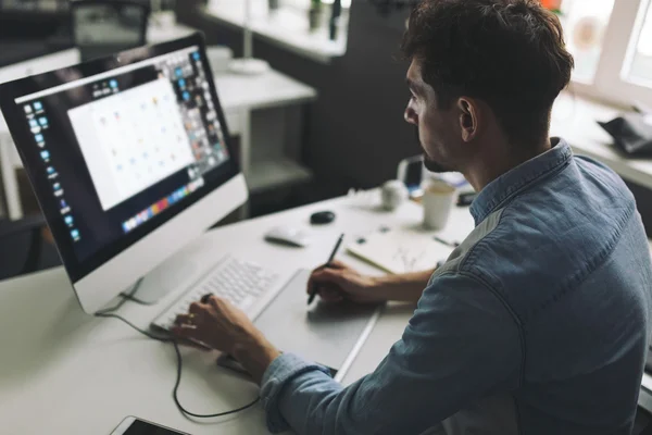 Junge Grafikdesignerin im Büro lizenzfreie Stockbilder