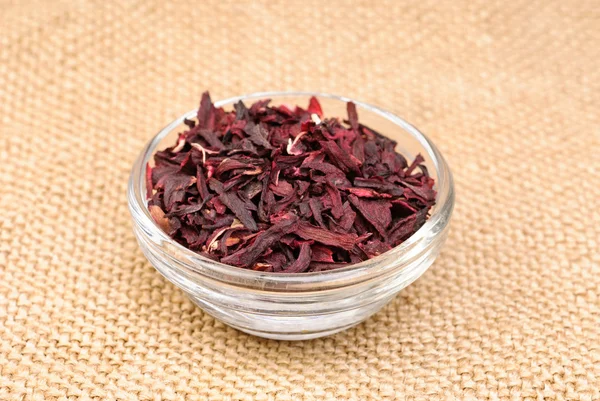 Гибискус чай макро сухой цветок на мешковине фоне — стоковое фото