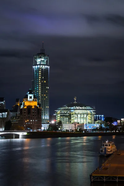 Blick auf das Haus der Musik und Hügel des swissotel krasnye holmy moscow am Ufer des Flusses in der Nacht — Stockfoto