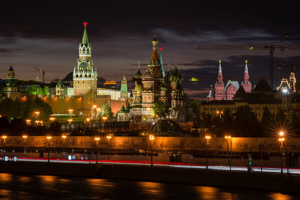 View to embankment of the river, walls of Moscow Kremlin and St. Basil's Cathedral from another side of the river in the sunset