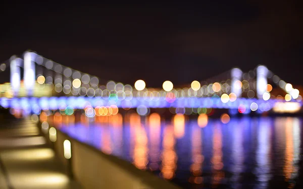 View from embankment of the river to blurry Krymsky Bridge in the night with water reflection — Stock Photo, Image