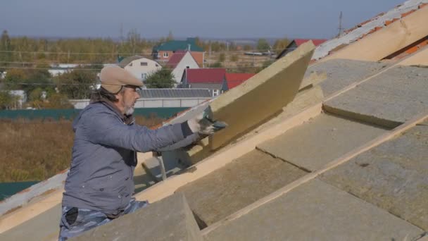 Работа на крыше. Установка изоляции для изоляции крыши частного дома. — стоковое видео