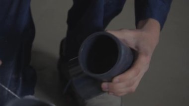 Kanalizasyon sisteminin plastik borularının kurulumu. Yüzeye şeffaf yapıştırıcı uygulanıyor.