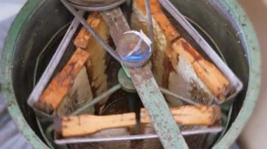 Bal peteğinden balın çıkarılması. Bal sökücü çerçevelerle dönüyor bal petekleri, bal pompalama. Bal peteğinden bal almak.