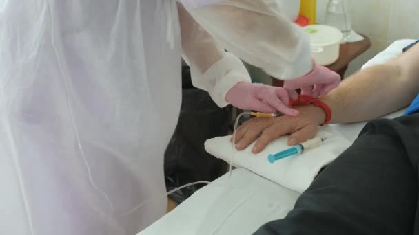 Injekce léků přes kapátko instalované v rukou osob. — Stock video